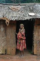 Elderly Pygmy woman in the doorway of a bark hut