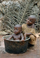 Pygmy baby taking a bath in a pot